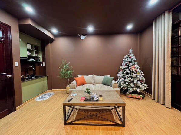 Una sala de estar con sofá, mesa de centro y un árbol de Navidad.
