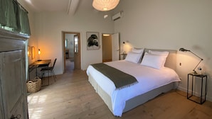 A bedroom with a bed, bedside lamps, a desk with a chair, and a hanging light fixture. - Mas en Provence with swimming pool - comfort and relaxation (Eyragues)