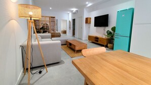 A modern living room with a sofa, wooden coffee table, and a TV mounted on the wall. - Travel Habitat Jesus-Patraix Family Apartment (Valencia)