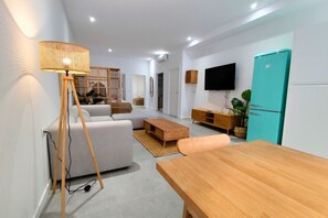 A modern living room with a sofa, wooden coffee table, and a TV mounted on the wall. - Travel Habitat Jesus-Patraix Family Apartment (Valencia)