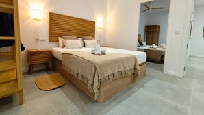 A bedroom with a bed, bedside tables, a wooden headboard, a ceiling fan, and a doorway leading to another room. - Travel Habitat Jesus-Patraix Family Apartment (Valencia)