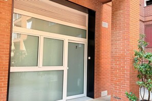 Ein Gebäude mit einer großen Glasdoor, Ziegelmauern und einer kleinen Pflanze.