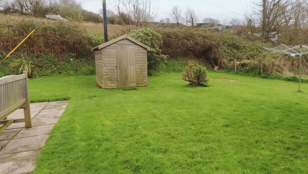 A wooden shed in a grassy yard with a bench and a clothesline. - Belan Wen (Beaumaris)