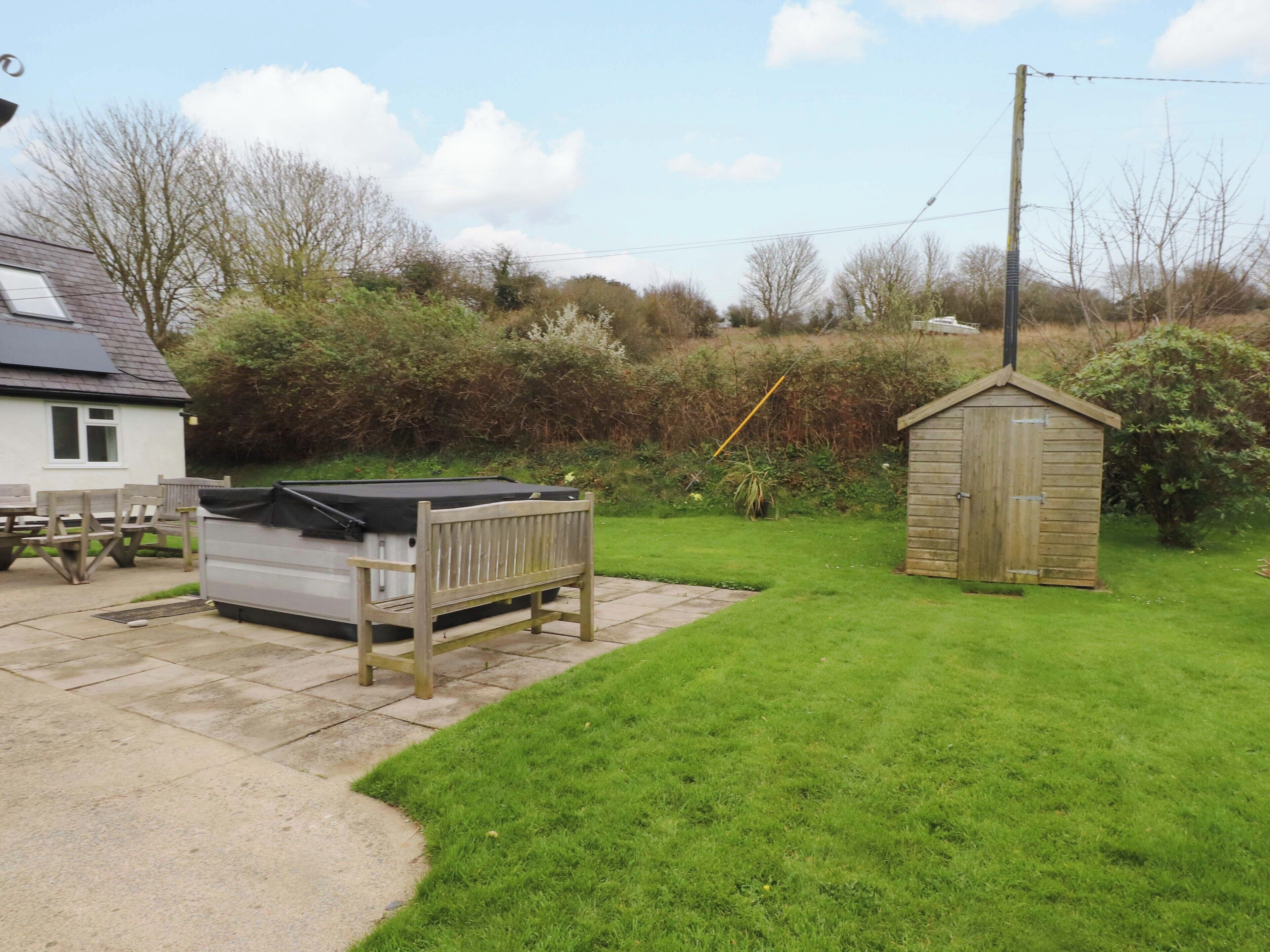 A backyard with a pool table, a shed, and a house.