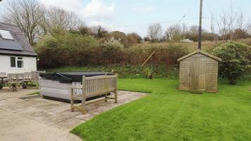 A backyard with a pool table, a shed, and a house.