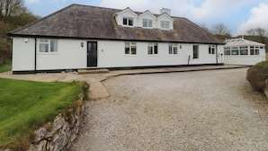 A two-story house with a gravel driveway and a small front porch. - Belan Wen (Beaumaris)
