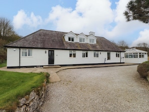 A two-story house with a gravel driveway and a small front porch. - Belan Wen (Beaumaris)