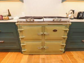 A vintage stove with two ovens, a kettle, and a toaster on a kitchen counter. - Belan Wen (Beaumaris)