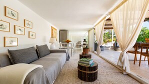 Un salon moderne avec un canapé, une table basse et des œuvres d’art encadrées accrochées au mur.