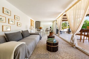 Un salon moderne avec un canapé, une table basse et des œuvres d’art encadrées accrochées au mur.