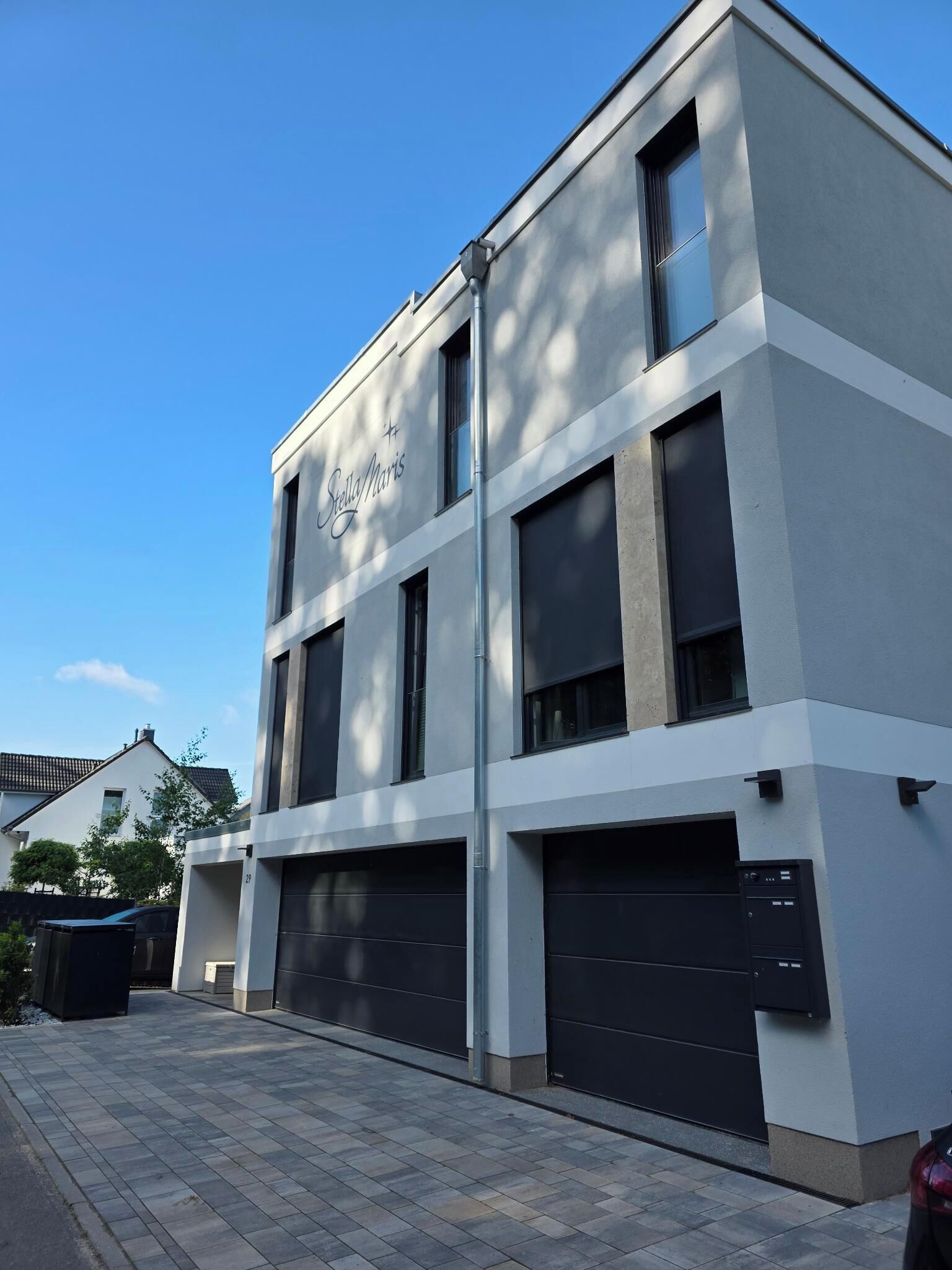 Un bâtiment moderne avec une enseigne indiquant « Stella/Maris » et de grandes portes de garage.