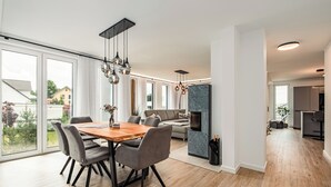 Una sala de estar moderna con comedor, ventanas amplias y chimenea.