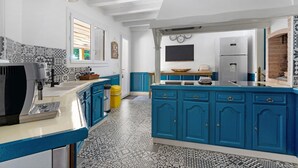 A kitchen with blue cabinets, a coffee machine, and a refrigerator. - Large Villa with Private Pool, Balcony and Wi-Fi in Saint-Georges des Coteaux (Saint-Georges-des-Coteaux)