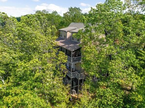 Une maison à deux étages, entourée d’une végétation luxuriante.