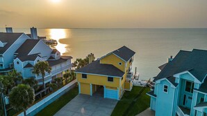 A coastal residential area with houses, a clear sky, and a sunset over the water. - Stunning Bayfront Home!  Panoramic Views, Fishing, Crabbing and Epic Sunsets. (Jamaica Beach)