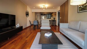 Un salon moderne comprenant un canapé, une table basse, un téléviseur et un coin repas avec des chaises.