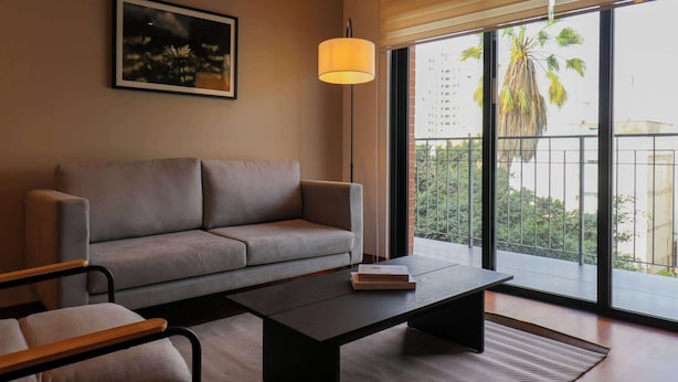 Un salon moderne avec un canapé, une table basse et un lampadaire.