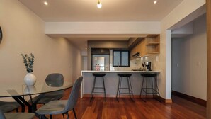 Une cuisine moderne dotée d’un îlot central, de tabourets de bar et d’une table à manger avec des chaises.