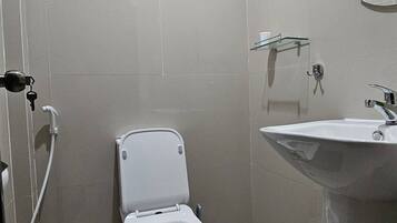 Un bagno moderno con WC, bidet e lavandino.