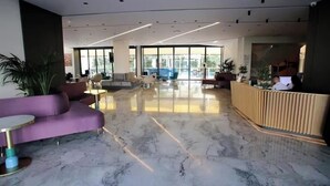 A modern lobby with a marble floor, a reception desk, and seating areas. - All Inclusive stay by PS - Durres Bay  (Rrashbull)