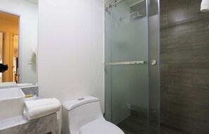 A bathroom with a toilet, a glass-enclosed shower, a marble sink, and a mirror. - w* | Luxury 3BR w/ Balcony in Upscale Miraflores (Miraflores)