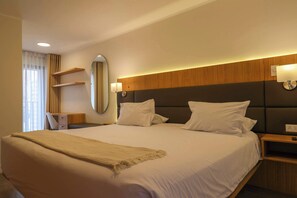 A hotel room with a large bed, bedside tables, a desk, and a mirror. - w* | Luxury 3BR w/ Balcony in Upscale Miraflores (Miraflores)