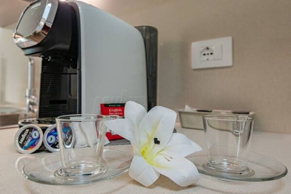 A coffee maker, two glasses, and a white flower on a countertop. - Penthouse-view tower-new-solarium-1km center-park (Pisa)