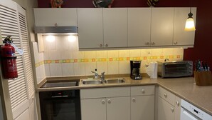 Una cocina con lavavajillas, horno, pileta y tostadora.