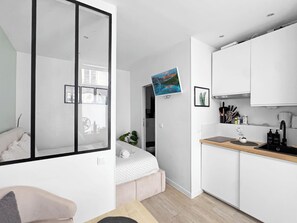 A modern apartment with a kitchenette, a bed with a view, and a large window. - Studio, 18 m² • 3 minutes from the Champs-Élysées & the metro (Paris)