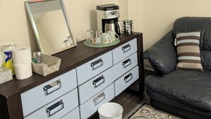 A living room with a coffee maker, a mirror, a sofa, and a patterned rug. - Tranquil poolside retreat!  Basement with 2 rooms! Close to Niagara Falls. (Niagara Falls)