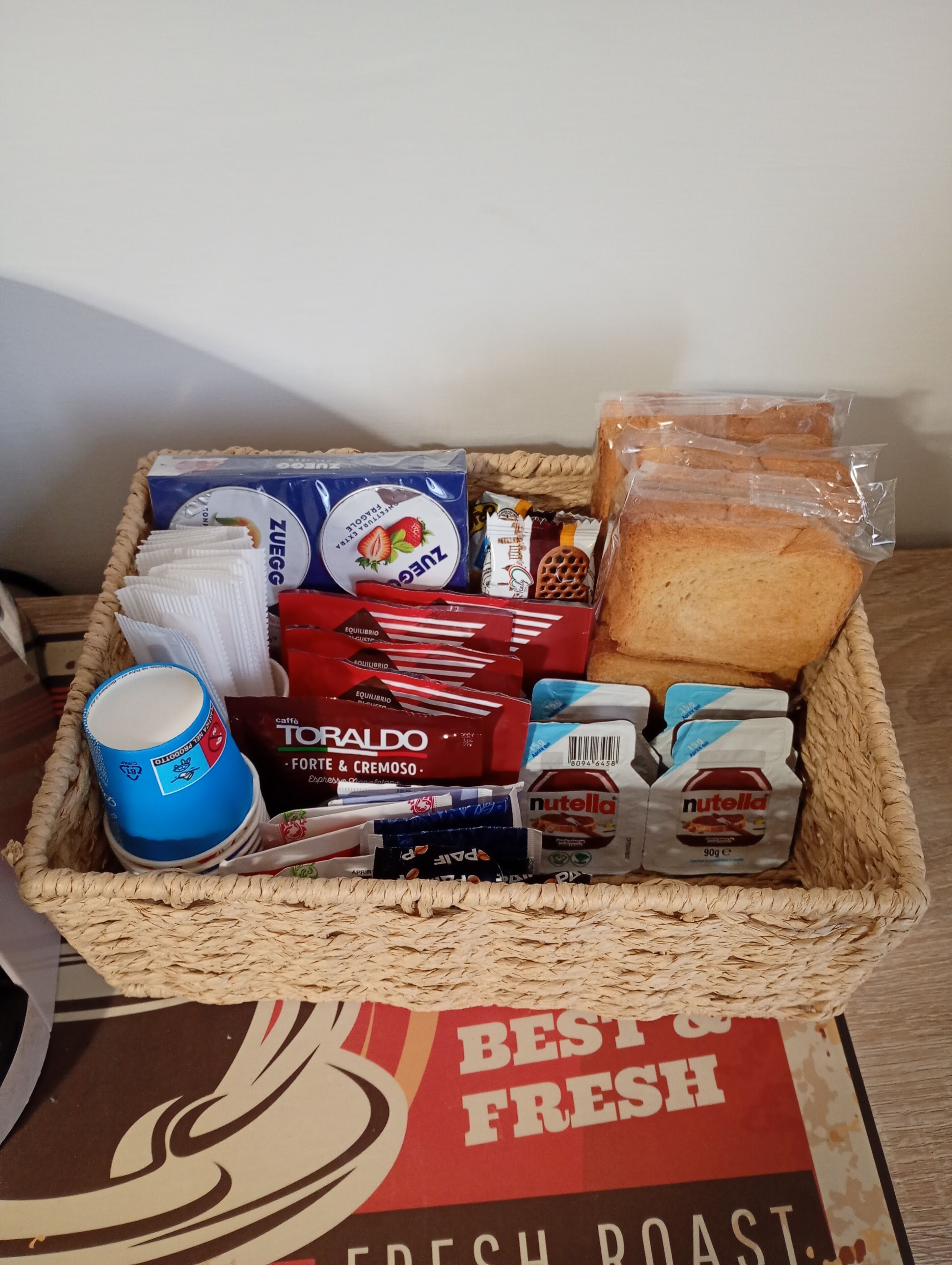 A basket containing various food items and a coffee cup.