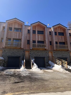 A multi-story building with wooden exterior walls, balconies, and garage doors. - Chalet, balcony, fireplace or stove, tv, 108m², Vars (Vars)
