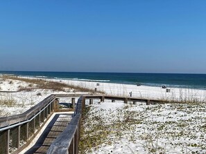 A beach with a wooden boardwalk leading to the shore, sandy dunes, and the ocean. - Family Retreat w/ Hot Tub, Garden Gate Estate (Pensacola)
