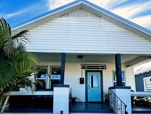 A single-story building with a gabled roof, a front door, and a small porch area. - Charming 3-bedroom house in Ybor/Tampa! Walk to Trolley for events (Tampa)