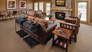 A spacious lounge area with a fireplace, comfortable seating, and artwork on the walls. - New Braunfels | Friends River Escape | Pool + River | 2BR (New Braunfels)