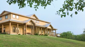 Ein zweigeschossiges Haus mit überdachter Veranda, Garage und geneigtem Dach.