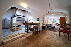 A spacious living area with a kitchen, wooden furniture, and a chandelier. - Vacation home in the Algarve for 8 people with pool Welcome to our Quinta (Boliqueime)