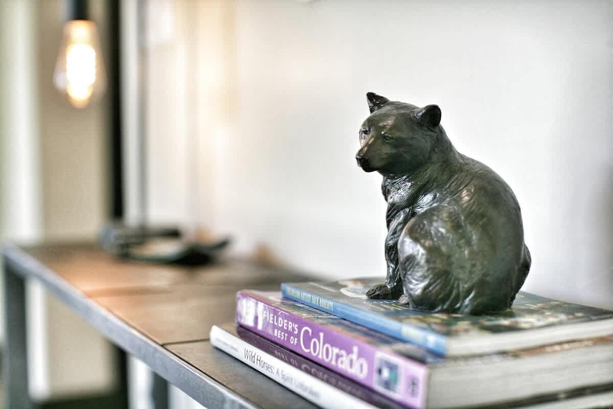 A bear statue on a stack of books.