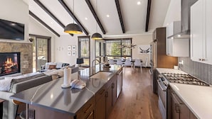 Una cocina moderna con una isla central, electrodomésticos integrados y un comedor con vistas.