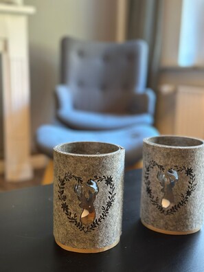 Zwei Kerzenständer mit Hirsch- und Blattmotiven auf einem Tisch.