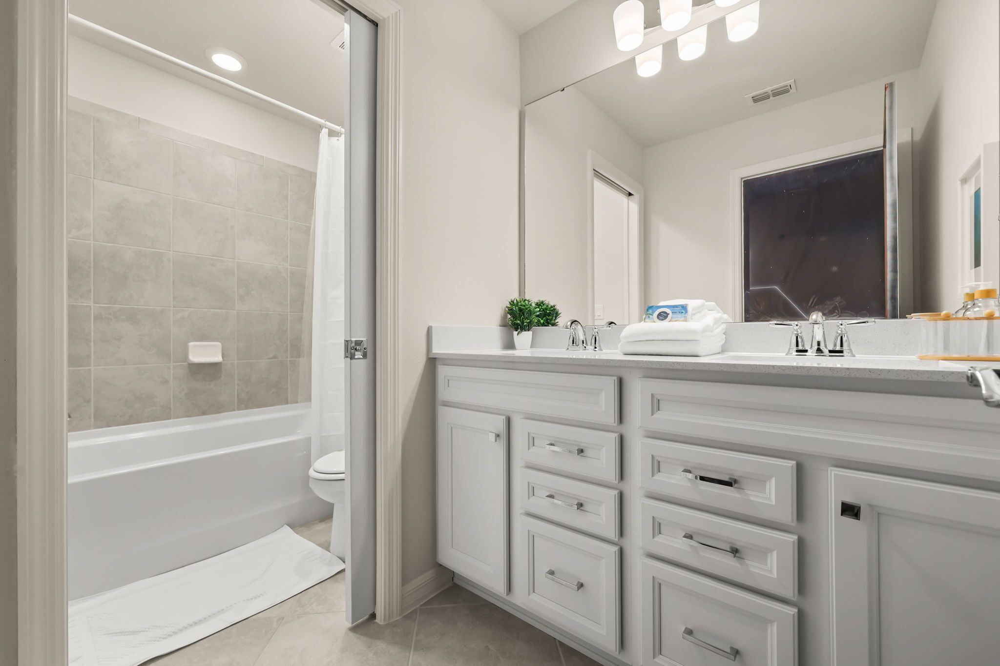 A modern bathroom with a walk-in shower, a bathtub, and a vanity with drawers.