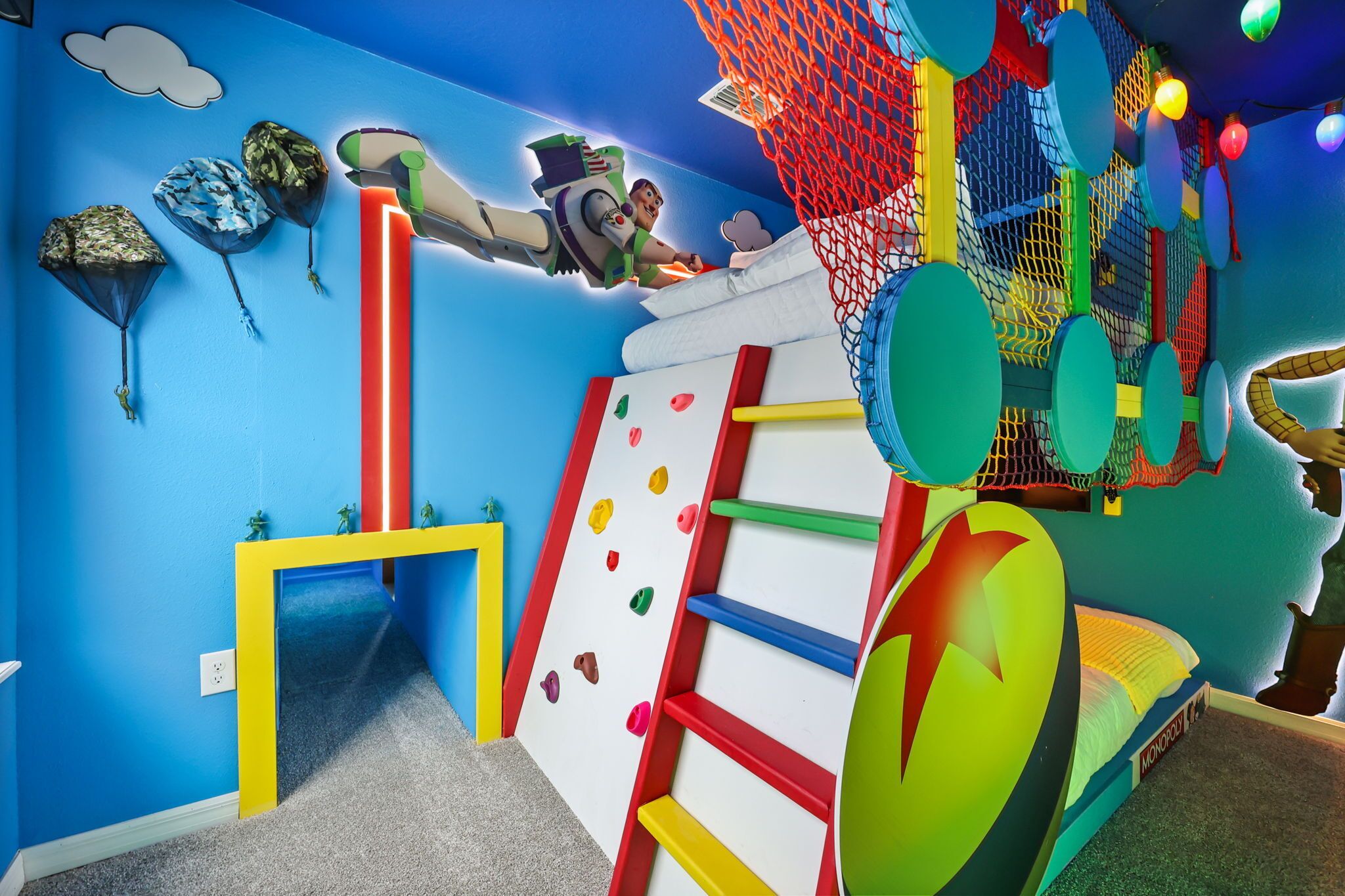 A children's play area with climbing walls, a slide, and colorful decorations.