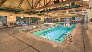 Una piscina interna con soffitto alto, sedute integrate e ampie finestre.