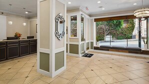 A hotel lobby with a reception desk, a large mirror, and a view of the outdoors. - San Francisco | Couples City Stay | Wi-Fi + Gym (San Francisco)