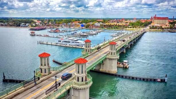 A bridge with towers, a marina with boats, and a distant building. - Beachside Condo Resort Sleeps 6 in Beautiful St Augustine! (St. Augustine)