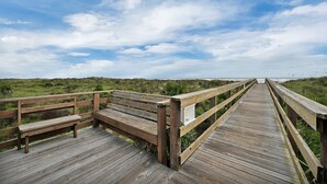 A wooden boardwalk leading to a beach with a clear sky. - Beachside Condo Resort Sleeps 6 in Beautiful St Augustine! (St. Augustine)