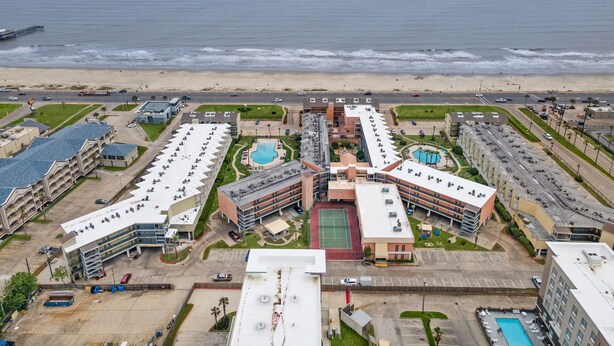 Een hotel met meerdere gebouwen, een zwembad en uitzicht op het strand.