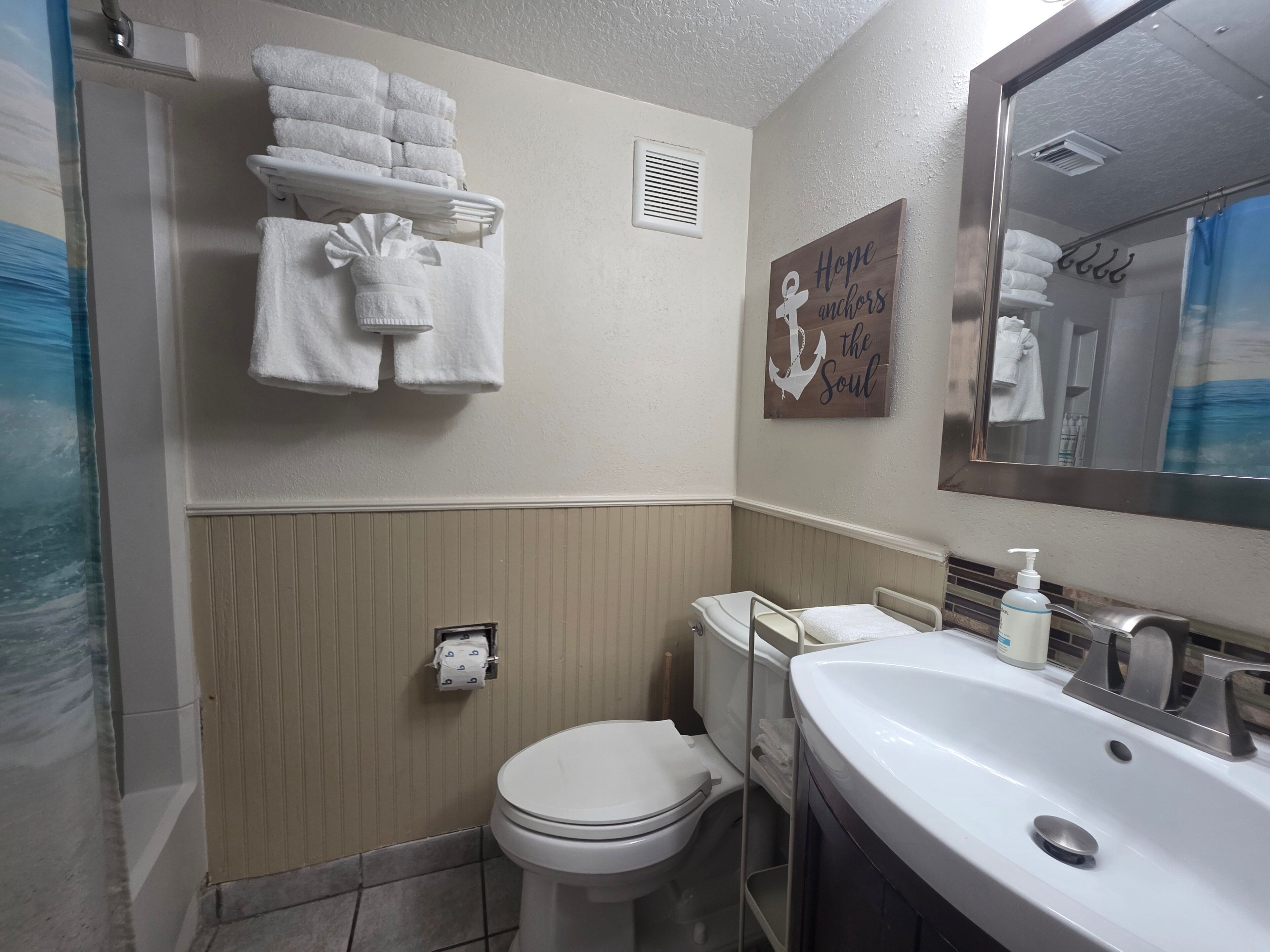 A bathroom with a toilet, sink, and towel rack.