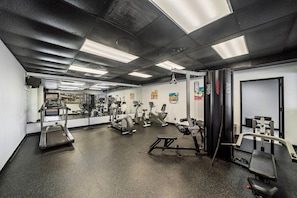 Ein Fitnessstudio mit Laufbändern, Crosstrainern und Gewichten.