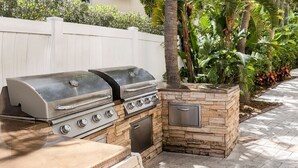 An outdoor kitchen with a grill, a built-in oven, and a storage cabinet. - Santa Barbara | Romantic Beach Retreat | Pool + Beach (Pompano Beach)